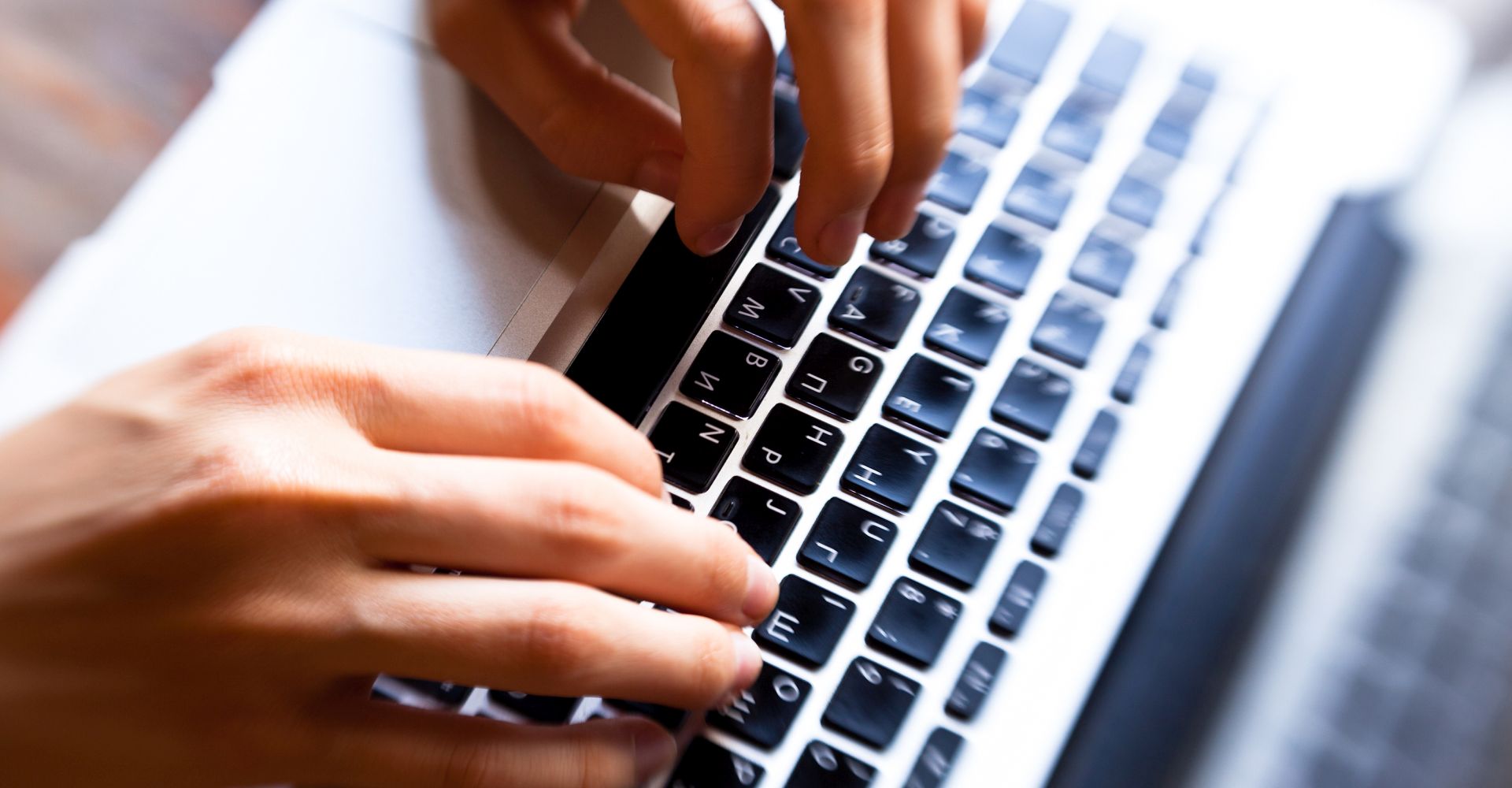 Hands typing on computer keyboard